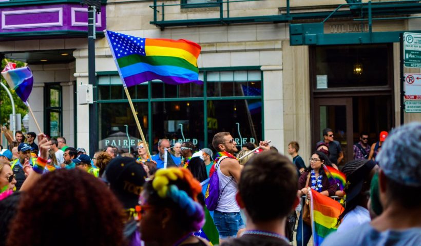 people gathered near building holding flag at daytime